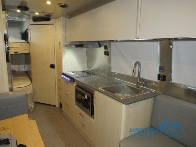 Airstream Flying Cloud 30FBBT travel trailer interior kitchen with stainless steel appliances and bunks in the rear